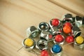 Bunch of arranged pins with vivid colorful pinheads and industrial metal nuts screws