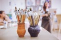 A bunch of art brushes standing in ceramic vases, on the table in the art studio Royalty Free Stock Photo