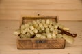 A bunch of artificial grapes in a wooden chest