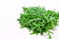 A bunch of arugula on white in the midday light. Heap of green fresh rucola or arugula leaf Royalty Free Stock Photo