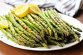 bunch of asparagus with grill marks displayed on a platter