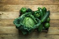 Bunch Assortment of Fresh Organic Green Vegetables Savoy Cabbage Zucchini Cucumbers Bell Peppers Avocados in Trey on Aged Wood