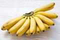 Bunch of baby banana on a white wooden background. Royalty Free Stock Photo