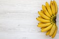 Bunch of baby banana on white wooden background, top view. Royalty Free Stock Photo