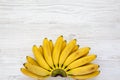 Bunch of baby banana. White wooden background, top view. Copy space Royalty Free Stock Photo