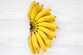 Bunch of baby banana. White wooden background, top view. Copy space.