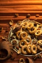 A bunch of bagels lie on a bronze platter, decorated with dried flowers and herbs. On a background of corrugated paper