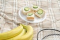 A Bunch of bananas ,badminton rackets and small summer sandwiches in the center for summer family sport picnic. Royalty Free Stock Photo