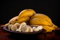 A bunch of bananas and a sliced banana in a bowl on a table Royalty Free Stock Photo