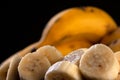 A bunch of bananas and a sliced banana in a bowl on a table Royalty Free Stock Photo