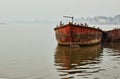 Bunch of birds sitting on a rusty old boat against mist foggy horizon in Varanasi located in a state of Uttar pradesh, India