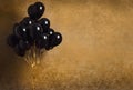 Bunch of black balloons on gold background Royalty Free Stock Photo