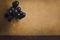 Bunch of black balloons on gold background Royalty Free Stock Photo