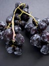 A bunch of black fresh grapes on the black surface. Royalty Free Stock Photo