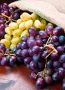 Bunch black and green grapes on wooden background