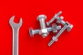 A bunch of bolts and nuts. Bolts, nuts and wrench