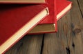 A bunch of books with a scarlet cover on a wooden table. Red books are thrown on the table. books with a red cover lie Royalty Free Stock Photo