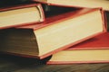 A bunch of books with a scarlet cover on a wooden table. Red books are thrown on the table. books with a red cover lie Royalty Free Stock Photo