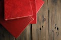 A bunch of books with a scarlet cover on a wooden table. Red books are thrown on the table. books with a red cover lie