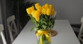 Bunch bright intense yellow tulips glass vase decorated band and bow. Spring