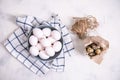 A bunch of brown quail eggs in a transparent bowl and a bunch of white chicken eggs in a blue bowl. Preparing for Easter