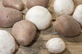 Bunch of champignon mushrooms and potatoes on wooden background close-up