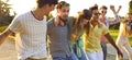 Group of happy cheerful young friends walking in summer park and having fun together Royalty Free Stock Photo