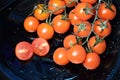 Bunch of cherry tomatoes on a black plate