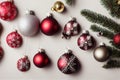a bunch of christmas ornaments hanging from a tree branch with a white background and a green pine branch with a red and silver Royalty Free Stock Photo