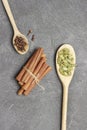 Bunch of cinnamon sticks on black. Cardamom and cloves in wooden spoons Royalty Free Stock Photo