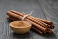 Bunch of cinnamon sticks tied with twine and powder in bowl Royalty Free Stock Photo