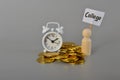 Bunch of coins, clock and wooden figure with text COLLEGE. concept investment education and scholarships