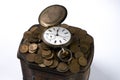 A bunch of coins with a pocket watch on top of Vintage jewelry box Royalty Free Stock Photo