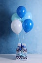 Bunch of color balloons and beautifully wrapped gift boxes on light blue background Royalty Free Stock Photo