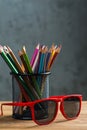 Bunch of color pencils and red sunglasses in a stand Royalty Free Stock Photo