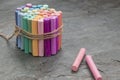 Bunch of colored pastel crayons with rose crayons aside on dark background