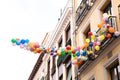 Bunch of colorful balloons in sky tethered to balcony
