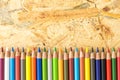 Bunch of colorful pencils, on flakeboard surface Royalty Free Stock Photo