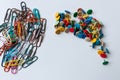 Bunch of colorful thumbtacks and many multi-colored paper-clips organize desktop and home office supplies as well as paperwork Royalty Free Stock Photo