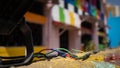 A bunch of colorful wires in the foreground over a yellow wall with a colorful building in the background