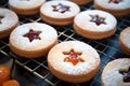 A bunch of cookies that are on a rack. Tasty linzer cookies