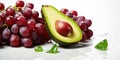 Bunch of crimson grapes lying next to glistening slices of ripe green avocado, both contrasting vividly against a white