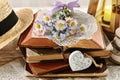 A bunch of daisy and forget-me-not flower lying on a stack of old books