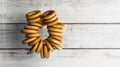 Bunch of delicious ring shaped Sushki dry bagels hanging near white wooden wall. Space for text