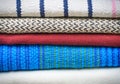 A bunch of different fabric textile blankets