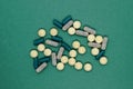 Bunch of different forms green medication pills on green background surface