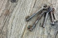 Bunch of different old rusty keys on dark wooden table