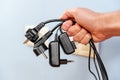 A bunch of disconnected electrical plugs with cables in a hand in room Royalty Free Stock Photo