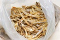 A bunch of dried anchovies fishes in a clear translucent plastic bag