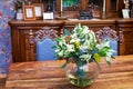Bunch of flowers in jug on table in old-fashioned